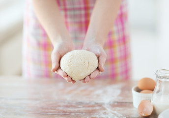 close up of female hands holding bread dough