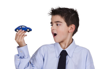 Naklejka premium boy looking at toy car in his hand