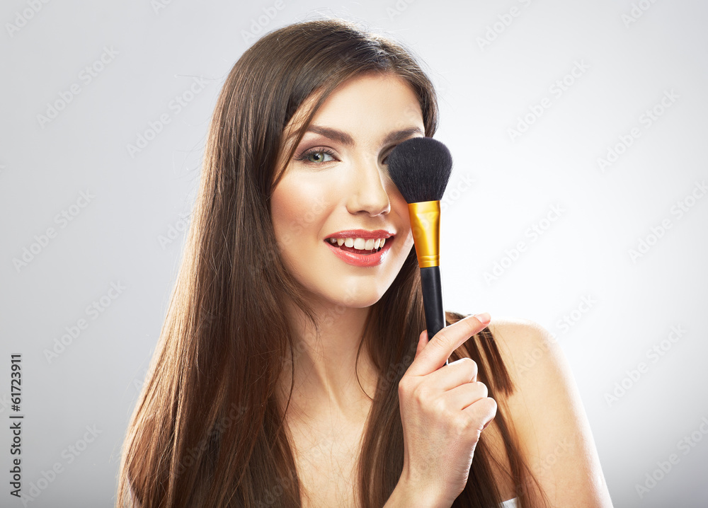 Wall mural Beauty portrait of young woman holding make up brush.