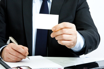 businessman with business card in foreground