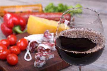 Red wine in the glass and food background