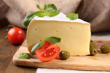 Tasty Camembert cheese with tomatoes, olives and basil,