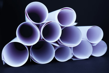 White paper rolls on black background close-up