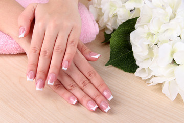 Beautiful woman hands with french manicure and flowers