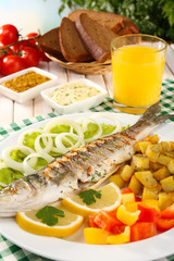 Delicious grilled fish on plate on table close-up