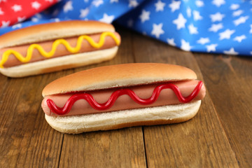 Tasty hot dogs on wooden table