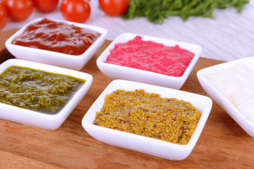 Various sauces on chopping board on table close-up