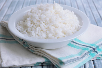 Cooked rice in bowl on wooden background