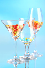 Goblets with pills on blue background