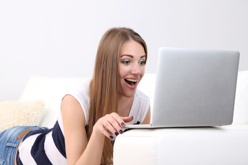 Young woman resting with laptop on sofa at home