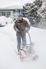 Man clearing driveway with snowblower