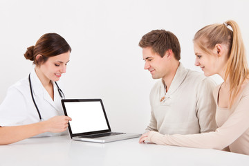 Fototapeta na wymiar Doctor And Couple With Laptop