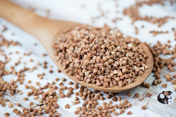 Wooden spoon with buckwheat kernels, close-up