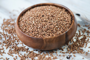 Raw buckwheat kernels in a wooden bowl, close-up