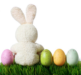 Colorful easter eggs and rabbit on grass, isolated