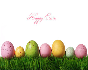 Colorful easter eggs on green grass isolated on white with copy