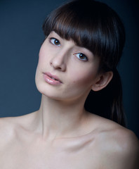 Woman with natural makeup on gray
