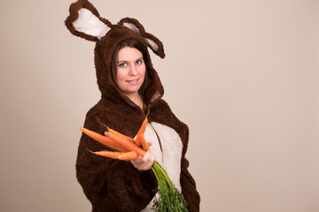 Frau im Hasenkostüm mit einem Strauß Möhren