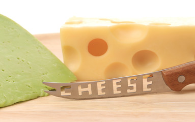 Delicious cheese and knife on wood.