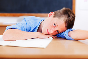 Schoolboy resting in classroom