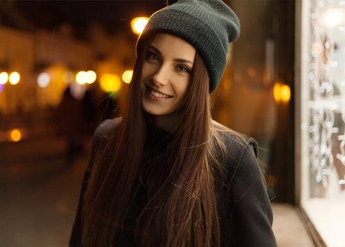 Beautiful girl smiling in the evening in the hat and coat