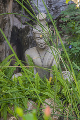 Statue sitting in lotus ascetic in the green grass.