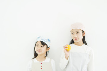 Two Japanese girls standing by the wall with lemon