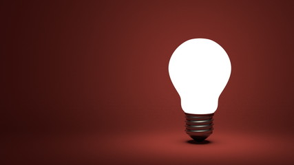 Glowing light bulb on red