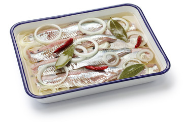 pickled herring on white enamel butcher tray