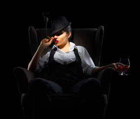 Young woman with cigar and brandy glass on chair
