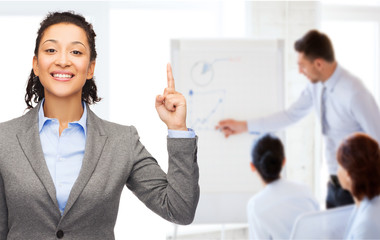 smiling businesswoman with her finger up at office