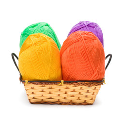 four yarn skeins in yellow, orange, green, purple colors in bask