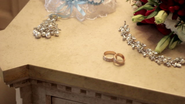 bridal bouquet and gold rings on the table