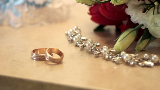 bridal bouquet and gold rings on the table