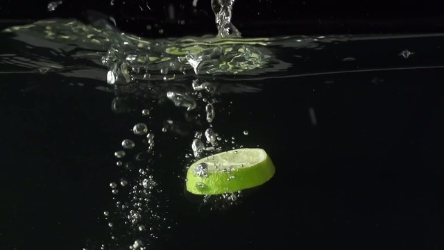 Parts of the lime and water splash in slowmotion