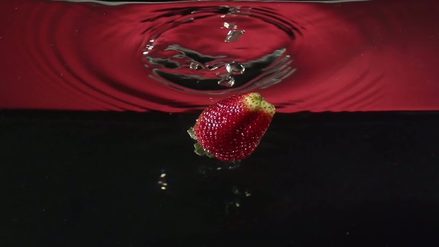 Strawberry  Drop Into Water In Slowmotion