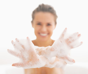 Closeup on young woman showing hands in foam