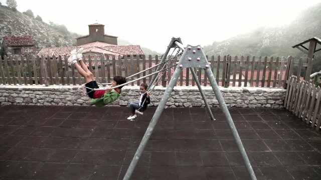 Ni&ntilde;os columpi&aacute;ndose