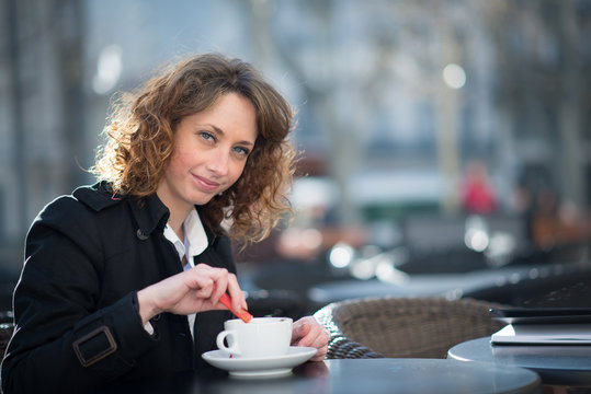 portrait of a beautiful young woman having tea in a café terrace