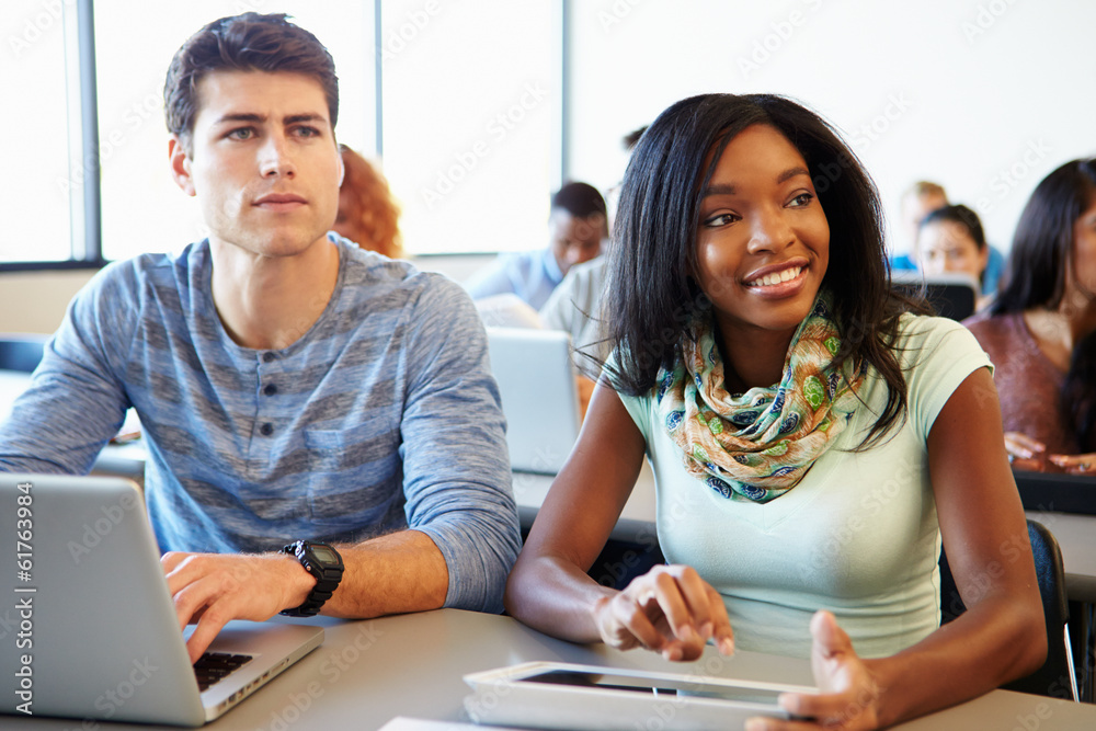 Wall mural university students using digital tablet and laptop in class