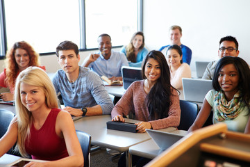University Students Using Digital Tablet And Laptop In Class