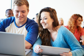 University Students Using Digital Tablet And Laptop In Class