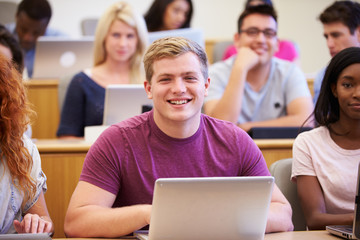Male University Student Using Laptop In Lecture