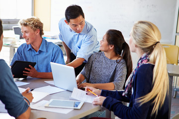 High School Students With Teacher In Class Using Laptops