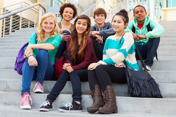 Portrait Of High School Students Sitting Outside Building - obrazy, fototapety, plakaty