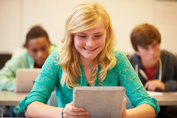 High School Student At Desk In Class Using Digital Tablet