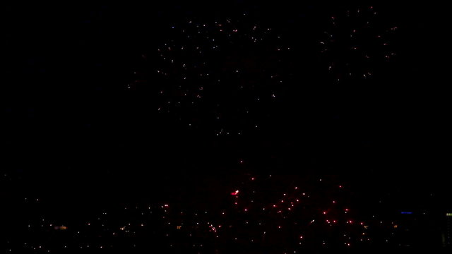 Fireworks flashing above the city at night.