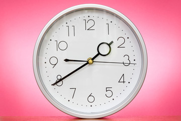 Clock over a pink background