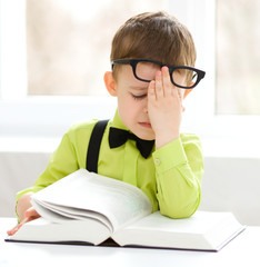 Little boy is reading a book