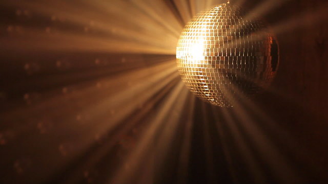 Shiny disco ball with golden reflection and rays in haze, HD 108